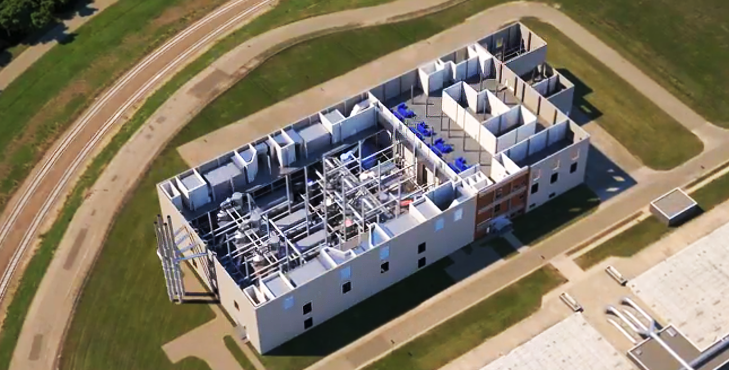 This is a 3D rendered image from the explainer video displays a bird's eye view of the Metro plant presenting the intricate arrangement of machinery that is inside of the plant.  Surrounding it, are grass and roads that accurately represent the actual site of the plant.