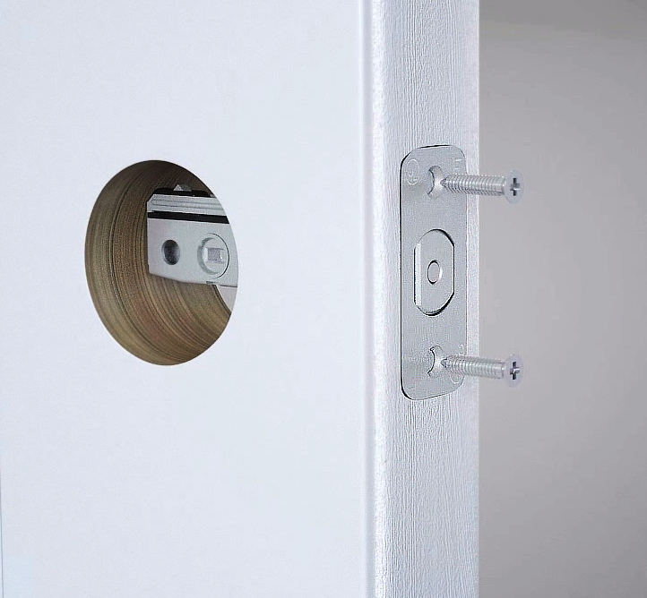 This is a 3D rendered shot from Trinity's 3D product visualization video demonstrating the installation process of the Yale Door Lock. In this shot, during the assemble of the door latch, two screws hover over their screw holes and are slowly placed and spun in- clearly showing the viewer how it is to be done.
