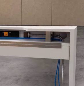 This still image from Trinity's contract furniture rendering provides visuals displaying the interior elements of the trough's electrical routing system. This is a close shot of the trough, displaying the ground power source manuevering through the interior of the trough which plugs into the extension and provides power to the individual workstations. 