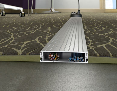 A cross section rendering of a cable management channel running under a carpeted floor, showing the internal cables.